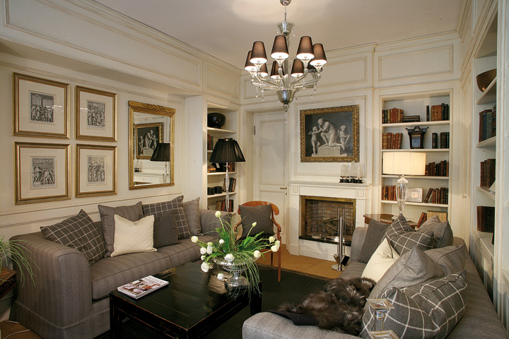 Boiserie bianca classica su misura per salotto: rivestimenti con cornici decorative Baggio Arredamenti.